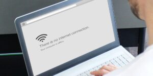 Person looking at a laptop screen showing a 'Let's connect you to a network' message with no internet access.