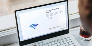Laptop screen displaying a 'There is no internet connection' warning while a person types on the keyboard